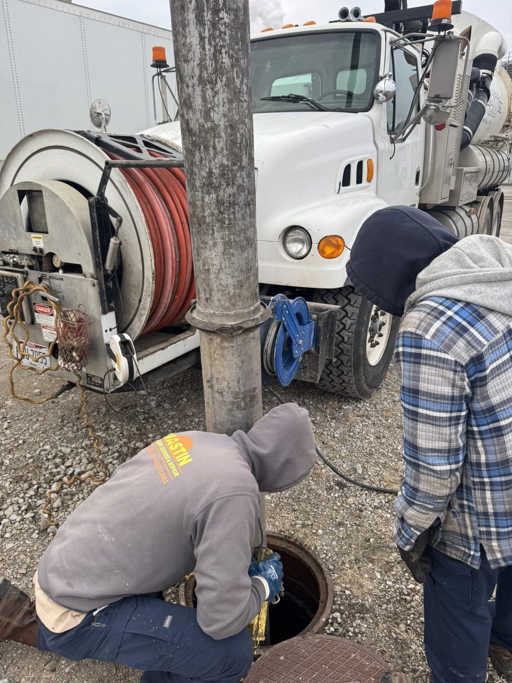 High-pressure jetter cleaning a storm structure manhole